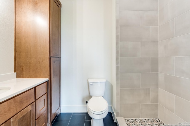 full bath with tile patterned floors, vanity, toilet, and tiled shower
