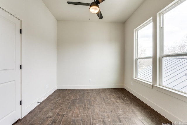 spare room with dark wood-type flooring, baseboards, and ceiling fan
