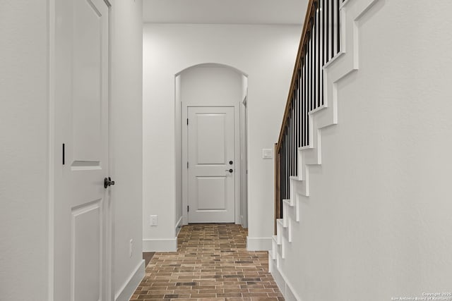 182 Torrey, New Braunfels, TX 78130 - hallway featuring brick patterned floors, arched walkways, baseboards, and stairway