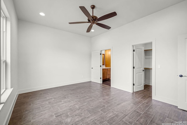 182 Torrey, New Braunfels, TX 78130 - unfurnished bedroom with dark wood finished floors, a walk in closet, recessed lighting, ensuite bath, and baseboards