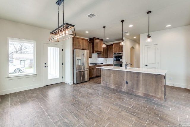 kitchen with visible vents, decorative backsplash, baseboards, light countertops, and stainless steel appliances