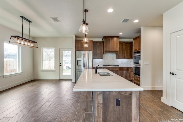 kitchen with stainless steel appliances, visible vents, a sink, and tasteful backsplash
