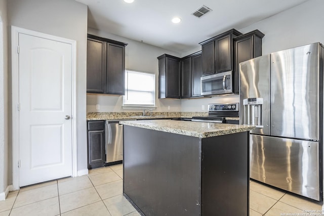 kitchen featuring light stone counters, stainless steel appliances, light tile patterned flooring, and visible vents