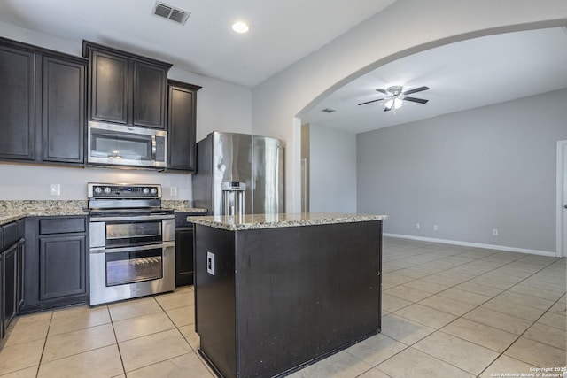 kitchen with a ceiling fan, visible vents, appliances with stainless steel finishes, light stone countertops, and light tile patterned floors