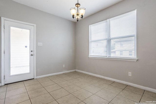 unfurnished room with an inviting chandelier, baseboards, and light tile patterned floors