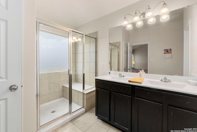 full bath with a sink, tile patterned flooring, a stall shower, and double vanity