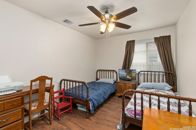 bedroom with dark wood-style flooring, ceiling fan, and visible vents