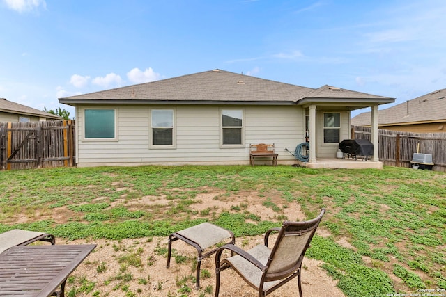 back of house featuring a fenced backyard, a lawn, and a patio area