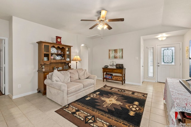 living area with baseboards, arched walkways, ceiling fan, and light tile patterned flooring
