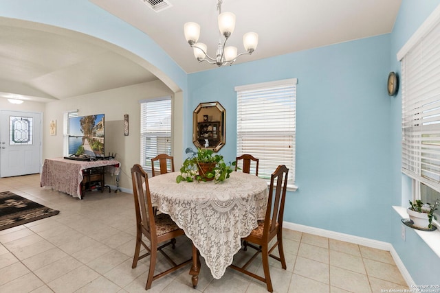 dining area with an inviting chandelier, arched walkways, a wealth of natural light, light tile patterned floors, and visible vents