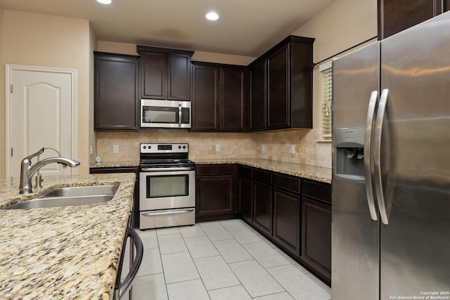 1843 Gray Fox, San Antonio, TX 78245 - kitchen with decorative backsplash, appliances with stainless steel finishes, light stone countertops, a sink, and light tile patterned flooring