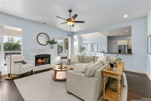 living room with visible vents, a high end fireplace, plenty of natural light, and wood finished floors