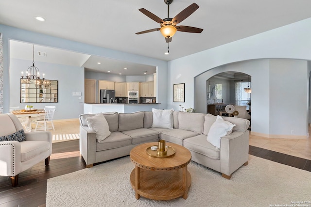 living area with visible vents, arched walkways, ceiling fan with notable chandelier, recessed lighting, and hardwood / wood-style floors