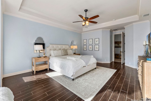 bedroom featuring a tray ceiling, visible vents, wood finish floors, and baseboards