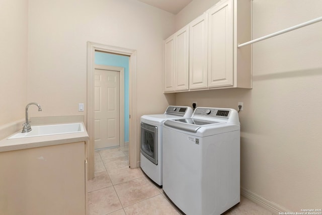 washroom featuring a sink, cabinet space, independent washer and dryer, and light tile patterned floors