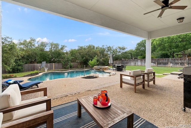 view of pool with a pool with connected hot tub, outdoor lounge area, a fenced backyard, a patio area, and a ceiling fan