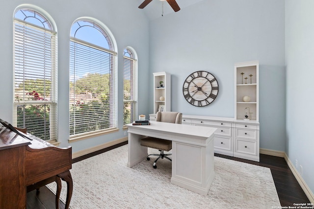 home office with dark wood-style flooring, ceiling fan, plenty of natural light, and baseboards