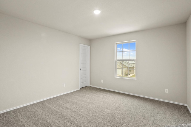 empty room with baseboards, recessed lighting, and carpet
