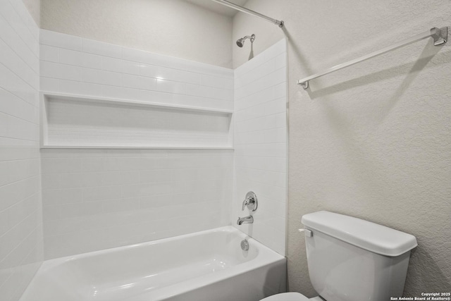 full bath featuring toilet, a textured wall, and washtub / shower combination