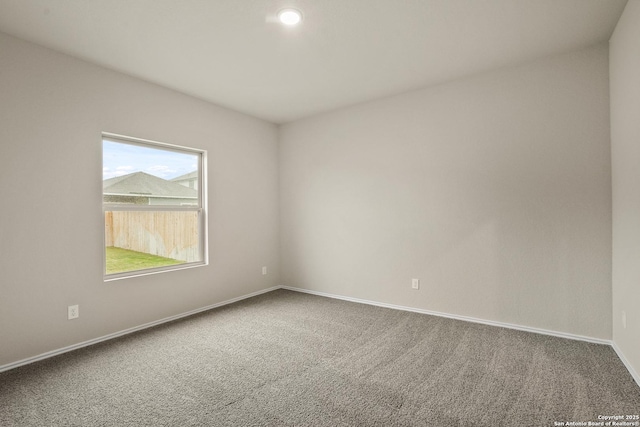 carpeted empty room with baseboards