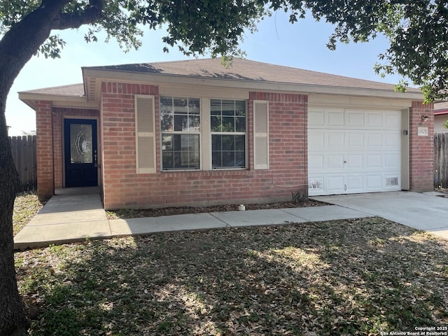 ranch-style home with fence, an attached garage, driveway, and brick siding