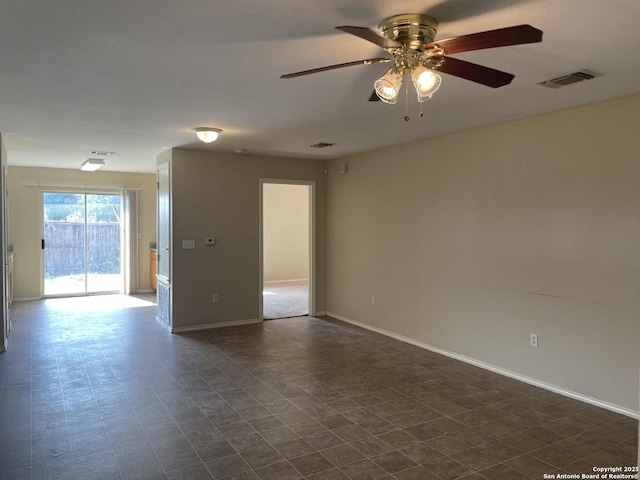 unfurnished room featuring baseboards, a ceiling fan, and visible vents