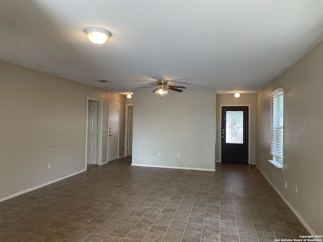 interior space with baseboards and ceiling fan