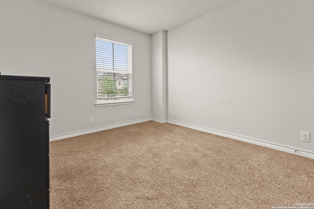 unfurnished room with baseboards and carpet