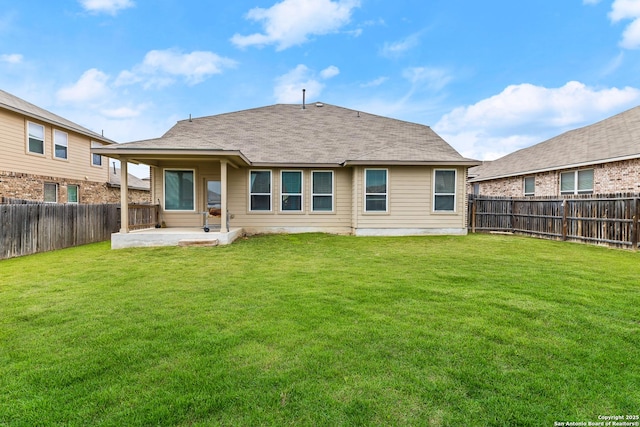 back of house featuring a lawn, a shingled roof, a fenced backyard, and a patio area