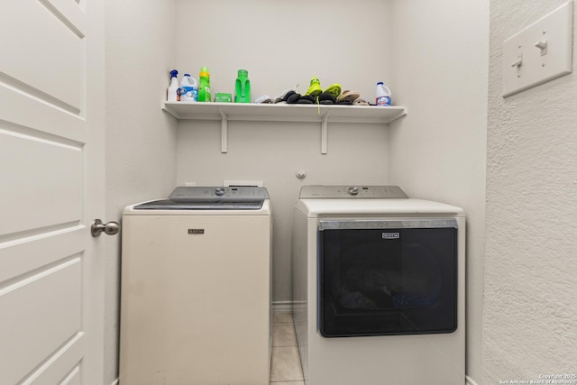 clothes washing area featuring independent washer and dryer, laundry area, and light tile patterned floors