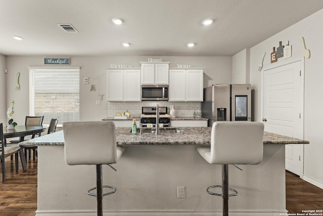 kitchen featuring dark wood-type flooring, a sink, white cabinetry, and appliances with stainless steel finishes
