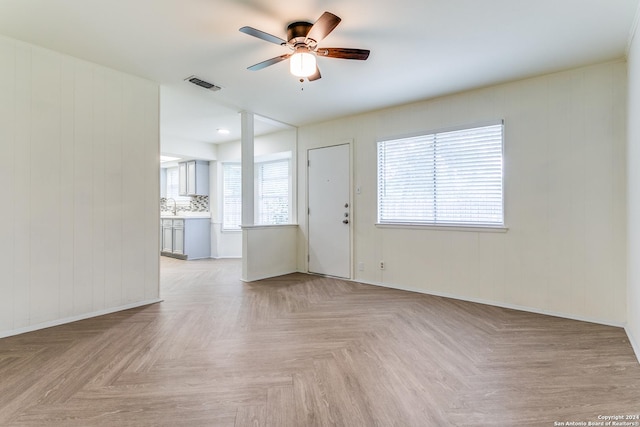7442 Castle Trail Dr, San Antonio, TX 78218 - unfurnished living room with a sink, baseboards, a ceiling fan, and visible vents