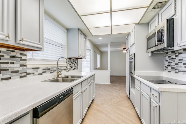 7442 Castle Trail Dr, San Antonio, TX 78218 - kitchen with visible vents, decorative backsplash, light countertops, a sink, and stainless steel appliances