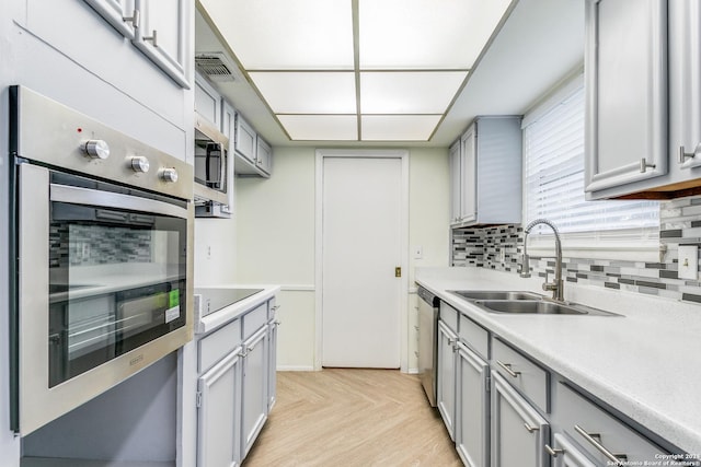7442 Castle Trail Dr, San Antonio, TX 78218 - kitchen featuring light countertops, gray cabinets, appliances with stainless steel finishes, and a sink