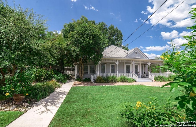 rear view of property featuring covered porch and a yard