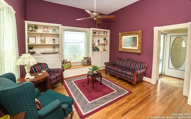 living area featuring a ceiling fan, lofted ceiling, and light wood-style floors