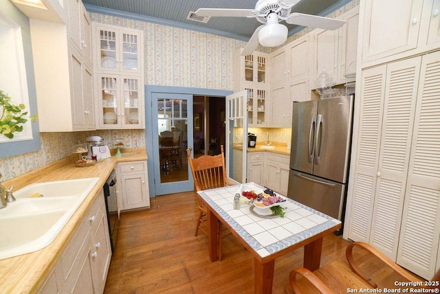 kitchen with freestanding refrigerator, wallpapered walls, and light countertops
