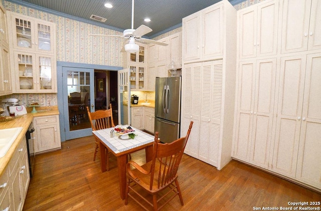 kitchen with freestanding refrigerator, visible vents, wood finished floors, and light countertops