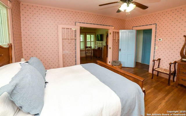 bedroom with crown molding, ceiling fan, hardwood / wood-style floors, and wallpapered walls