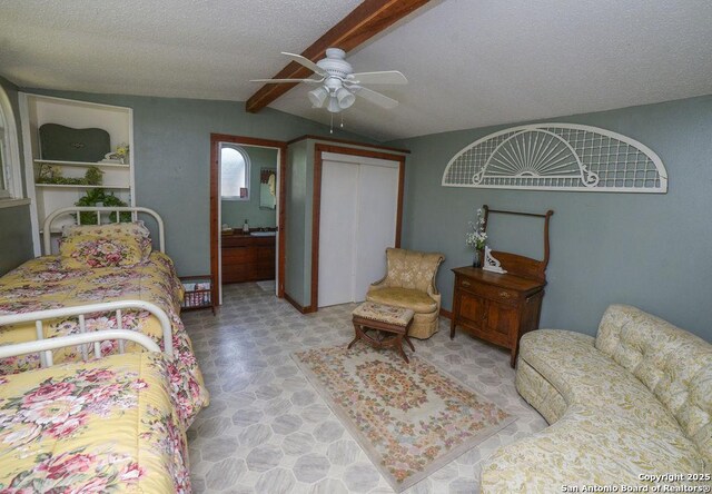 bedroom with a ceiling fan, a textured ceiling, vaulted ceiling with beams, and a closet