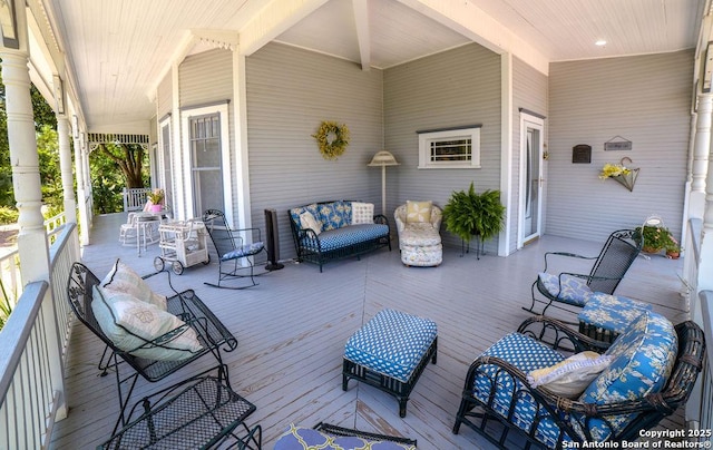 wooden deck featuring covered porch and an outdoor hangout area