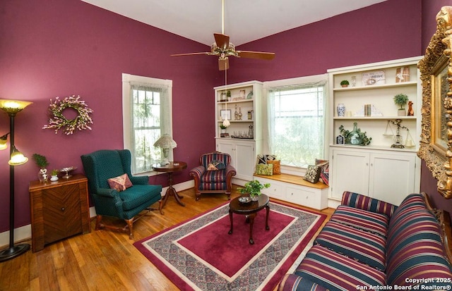 sitting room with ceiling fan, vaulted ceiling, a healthy amount of sunlight, and wood finished floors