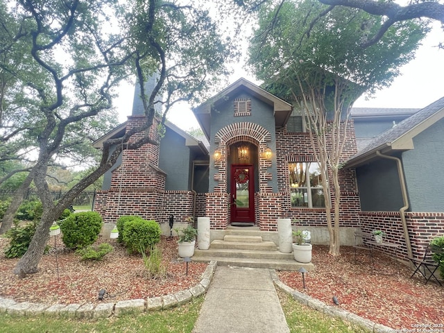 view of exterior entry featuring brick siding