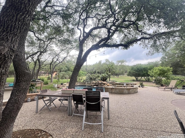 view of patio with a fire pit and outdoor dining area