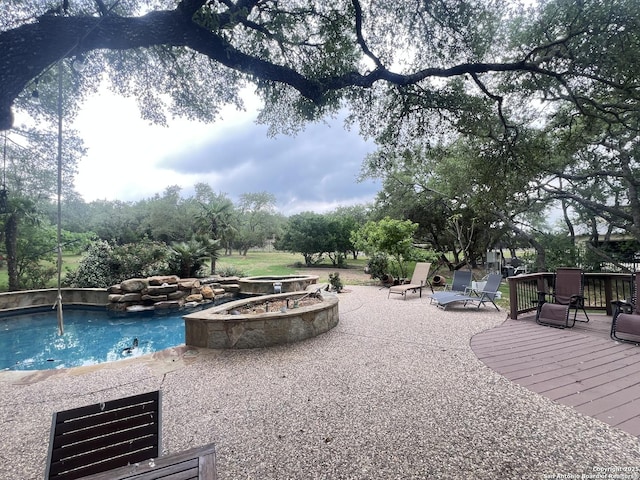 outdoor pool with a patio and an outdoor fire pit