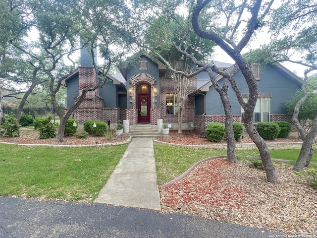 tudor house with brick siding and a front yard
