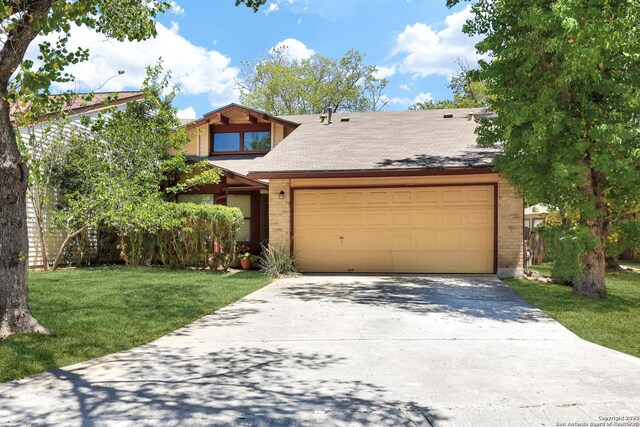 view of front of house with a garage, a front yard, driveway, and brick siding