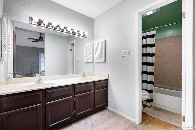full bathroom featuring double vanity, a textured wall, a sink, and toilet