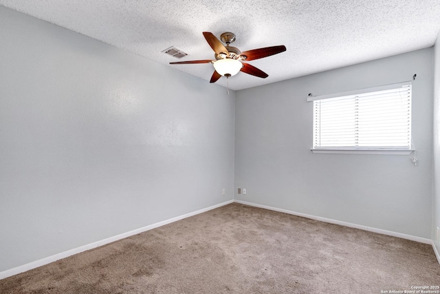 carpeted spare room featuring a ceiling fan, baseboards, visible vents, and a textured ceiling