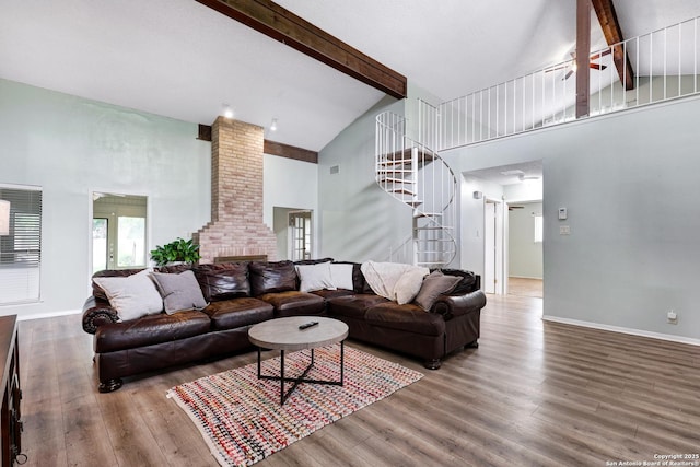 living room featuring ornate columns, stairs, beam ceiling, and high vaulted ceiling